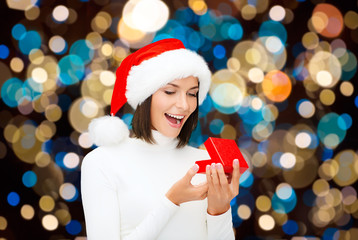 happy woman in santa hat opening christmas gift