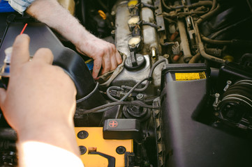 hands of an auto mechanic close-up. servicing and caring for a car engine