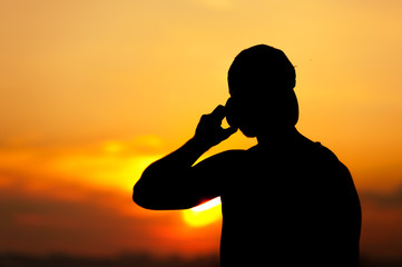 Silhouette of young man using his mobile phone