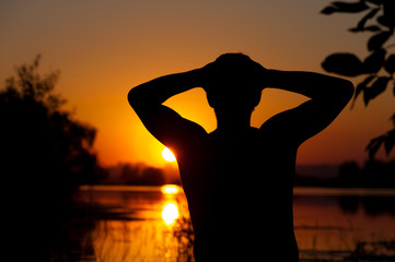 Silhouette of relaxed man at river or lake water