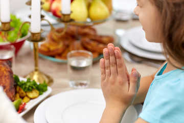 Obraz na płótnie Canvas close up of girl having dinner and praying at home