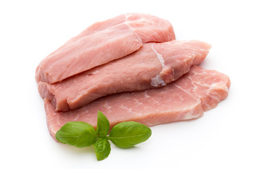Fresh pork fillet with basil on a white background.