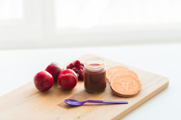 fruit puree or baby food in jar and feeding spoon