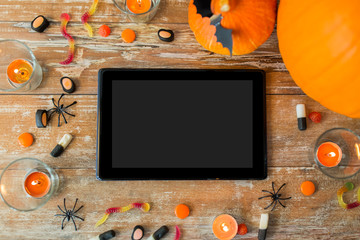 halloween pumpkins, candies, candles and tablet pc