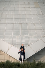 Mom and daughter against the glass architecture