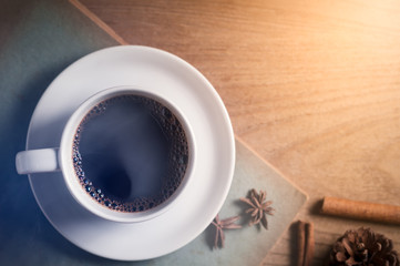 Coffee cup with old book on rustic wooden table, classic concept.