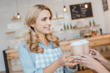 waitress holding disposable coffee cups