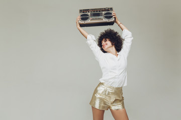 Emotional retro woman dressed in shirt holding boombox.