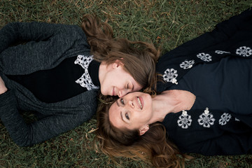 Mom and daughter repose on grass
