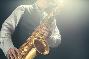 Obraz premium Young man playing the Saxophone