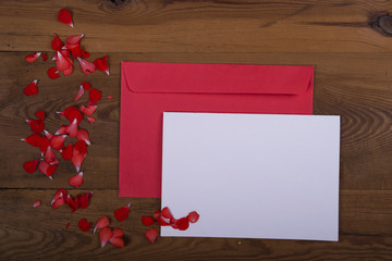 Top view of envelope and blank greeting card with flowers on  wooden background. Desktop with blank page mock up, open envelope and peony flower, Creative concept, empty greeting card
