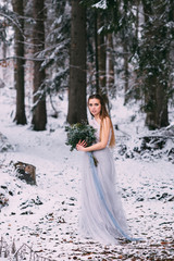 Fototapeta na wymiar Beautiful winter portrait of young woman in the winter snowy scenery.