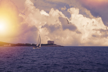 Naklejka na ściany i meble Photo of a beautiful scenic sea and sky landscape. Yacht in sea. Lightly toned