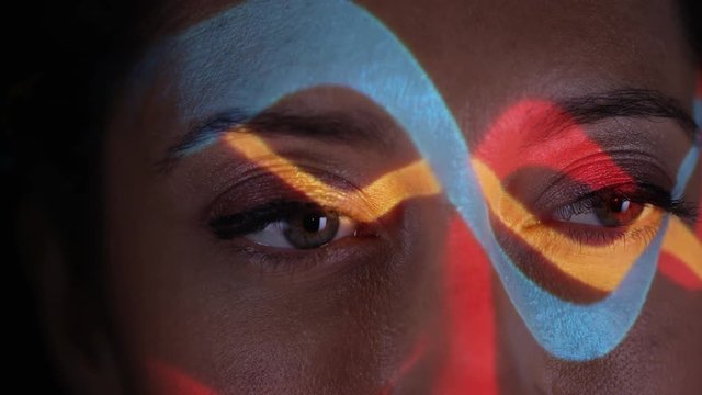  Close up colorful patterns of light projected onto face of attractive model