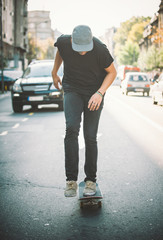 Pro skateboard rider in front of car on city road