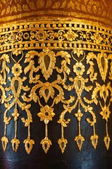 Vintage golden concrete stucco design of native traditional Thai mural art pattern decorated on the pole in main hall of Wat Phumin or Phu Min Temple, The famous ancient temple in Nan, Thailand