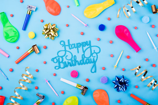 Happy birthday. Festive candles, party confetti, balloons, streamers and decoration on blue background. Colorful celebration pattern. Flat lay