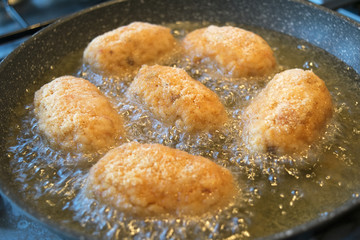 rice croquettes frying in olive oil
