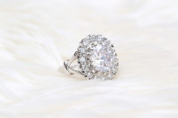 Diamond ring on white fabric background