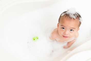 attractive little boy kid playing toy in foam