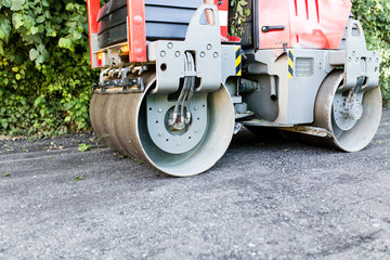 heavy machine rolls a new asphalt road