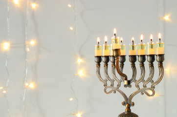 Fototapeta premium Image of jewish holiday Hanukkah background with menorah (traditional candelabra) and burning candles