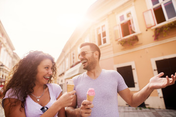 Young happy couple enjoying ice cream and summer in the city.
