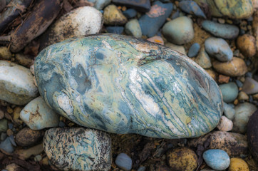 Colorful stones on a mountain river bank, colorful texture background, summer morning