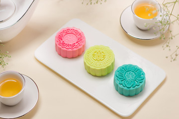 Colorful snow skin mooncake with tea pot on pink background