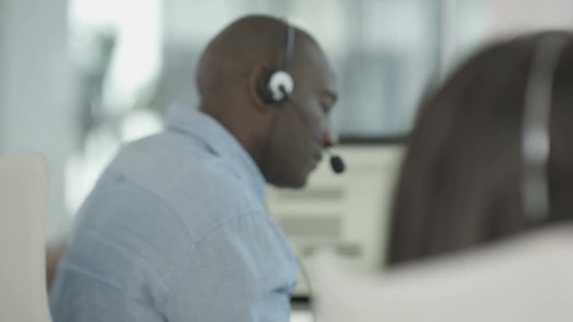  Friendly financial advice team taking calls in busy call center