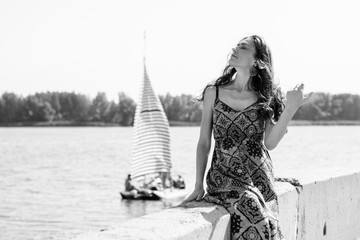 Middle aged stylish woman wear in long silk dress on a beach rest at good sunny day, nature background 