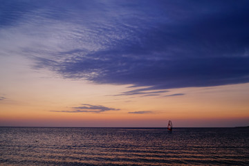 Fototapeta na wymiar Windsurfing on the sunset at the sea