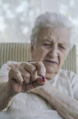 senior woman holding a pill