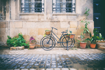 Fototapeta na wymiar Bicycles parked near stone brick wall of old house among plants in pots in Icheri Sheher, Baku, Azerbaijan