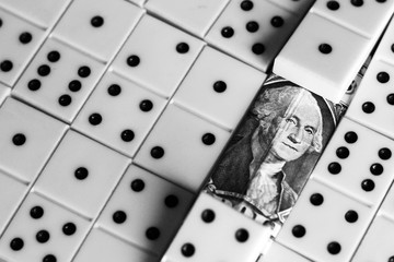 business and finance concept - dominoes and us dollar.