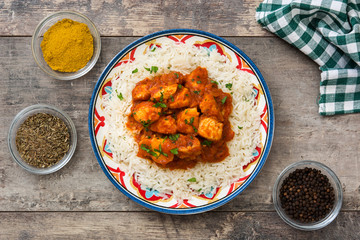 Chicken tikka masala with basmati rice on wooden table. Top view