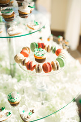 Delicious and tasty dessert table with cupcakes shots at reception closeup