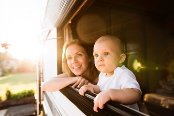Mother and baby son in a camper van. - obrazy, fototapety, plakaty