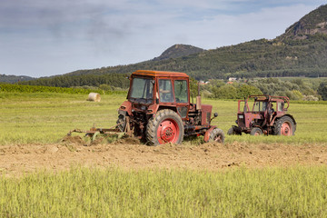 Obraz premium Old tractor working on the field