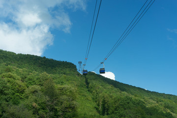mountain landscape on background of blue cloudy sky and a view of the cable car