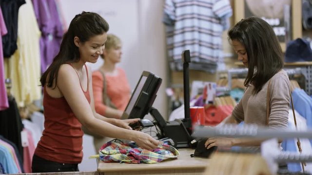  Customer in clothing store paying for a purchase with her credit card