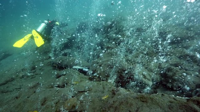 Scuba divers taking photos of hot bubbles rising from underwater volcano in Pulau Weh, Aceh, Indonesia 