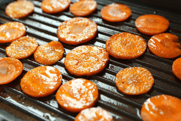 Carrot slices on frying pan, closeup