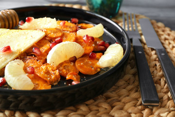 Carrot salad with apple and pomegranate seeds on plate, closeup