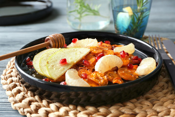 Carrot salad with apple and pomegranate seeds on kitchen table