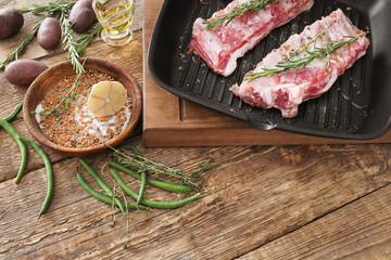 Grill pan with fresh raw ribs on table