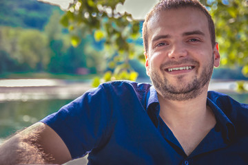 Portrait of a handsome young man with beard smiling