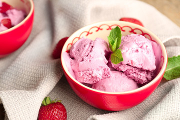 Bowl with delicious strawberry ice-cream on table