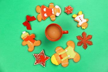 Tasty Christmas homemade cookies and cup of coffee on color background
