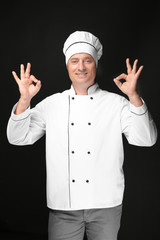 Male chef in uniform on black background